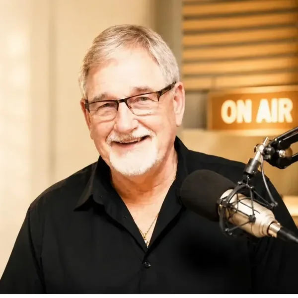 Jim Parr at the microphone in the studio, under an On Air sign.